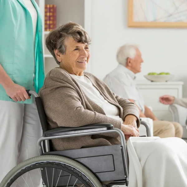 senior in wheel chair being pushed by caregiver