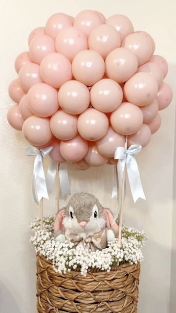 Bunny stuffed animal inside a hot air balloon basket. 