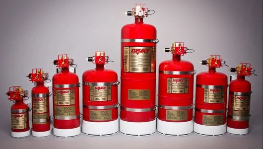 Various sizes of red fire suppression cylinders arranged in a row.