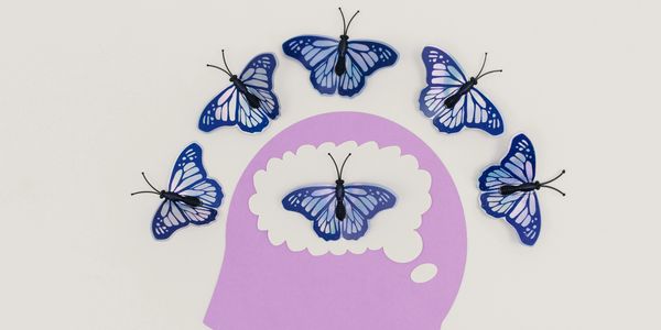 Blue butterflies around and inside a purple silhouette of a head.