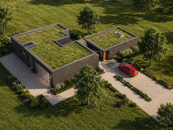 Modern home with green roofs and a red car in the driveway.