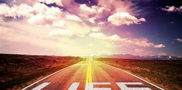 A road stretching into the horizon with the word LIFE painted on the pavement.