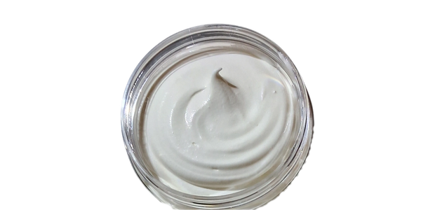 Open jar of creamy white lotion or cream.