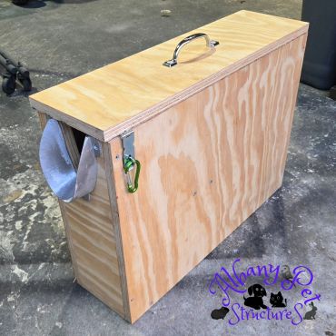 Wooden pet carrier box with handle and fabric entrance.