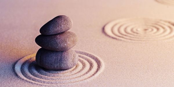 A peaceful zen garden of raked sand and smooth stacked stones.