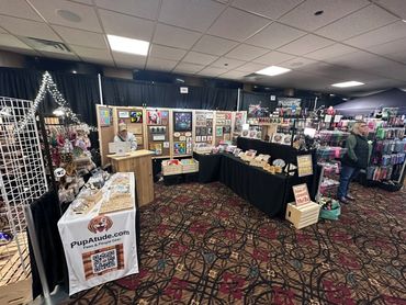 Craft booth at an indoor market selling pet-themed and novelty items.