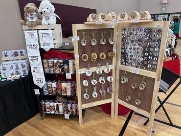 Display of dog-themed merchandise including bandanas, tumblers, ornaments, and magnets.