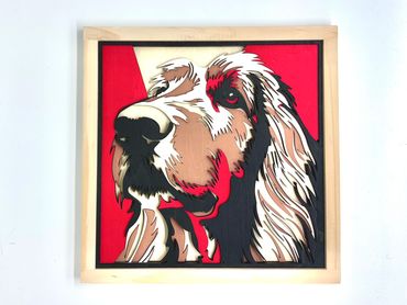 Colorful layered wooden artwork of a dog's face with a red background.