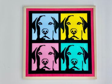 Pop art style dog portraits in four colorful panels with a pink border.