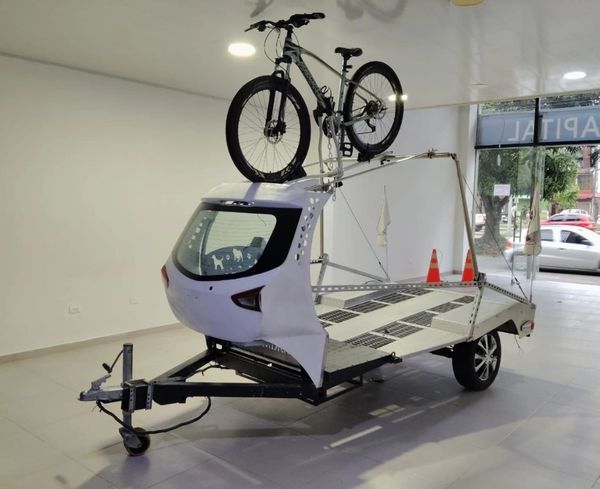 A unique bicycle trailer with a bike mounted on top.