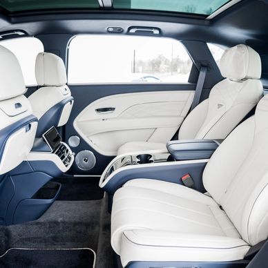 Luxurious white leather interior of a modern car with spacious seating.