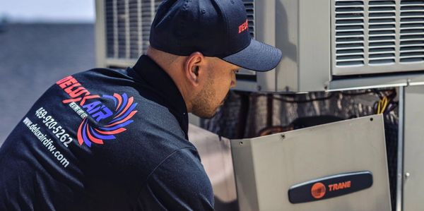 HVAC technician working on AC unit
