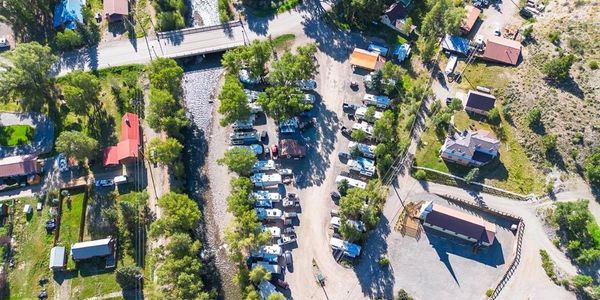 Aerial view of a parking area with RVs and surrounding greenery.