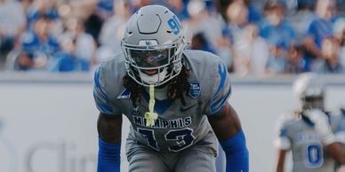 Memphis football player in gray uniform focused on the game.