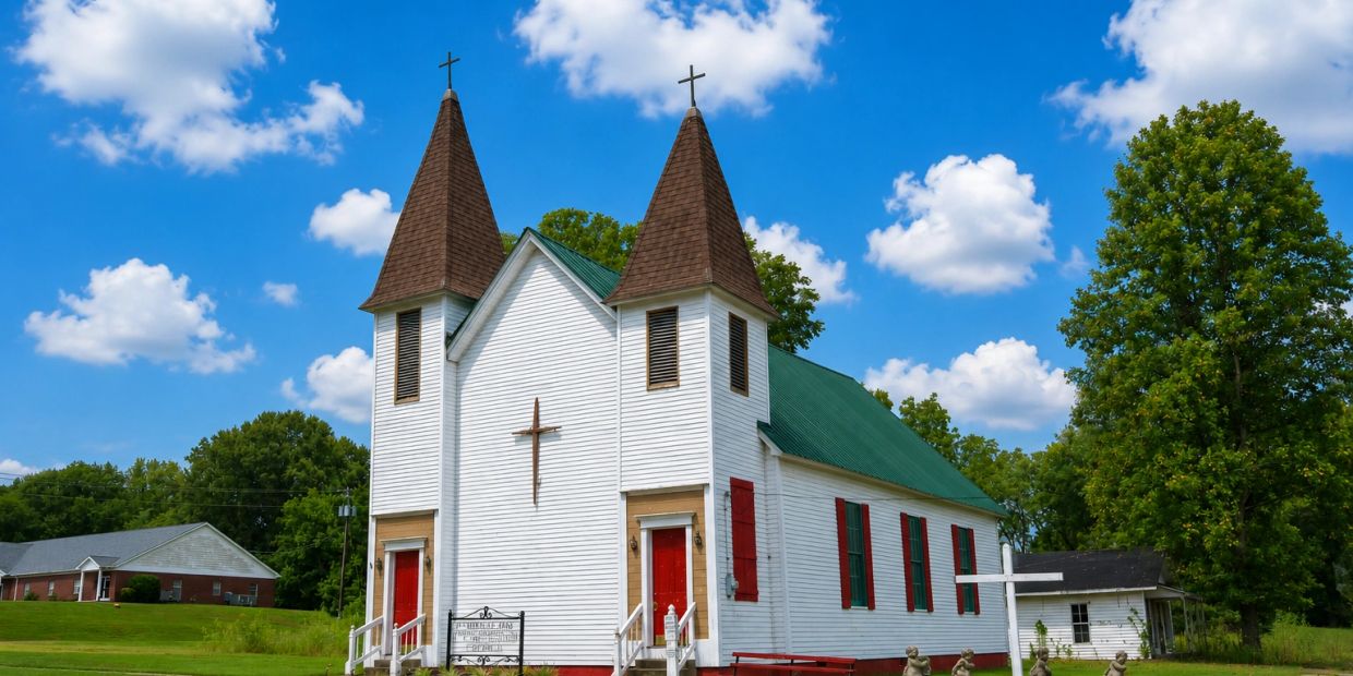 White church with twin steeples under blue sky.