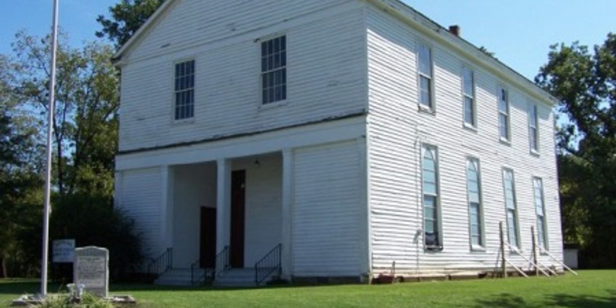 A white historic two-story building with many windows.