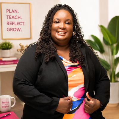 Smiling woman in colorful top and black blazer.