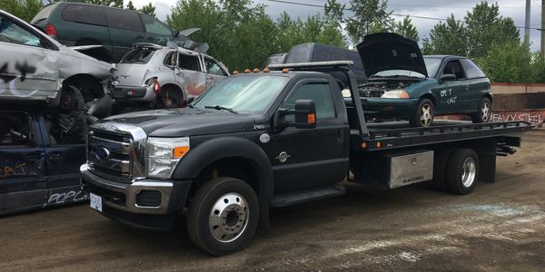 Jay's Junk Car Towing tow truck With a Scrap Car Getting ready to be recycled 