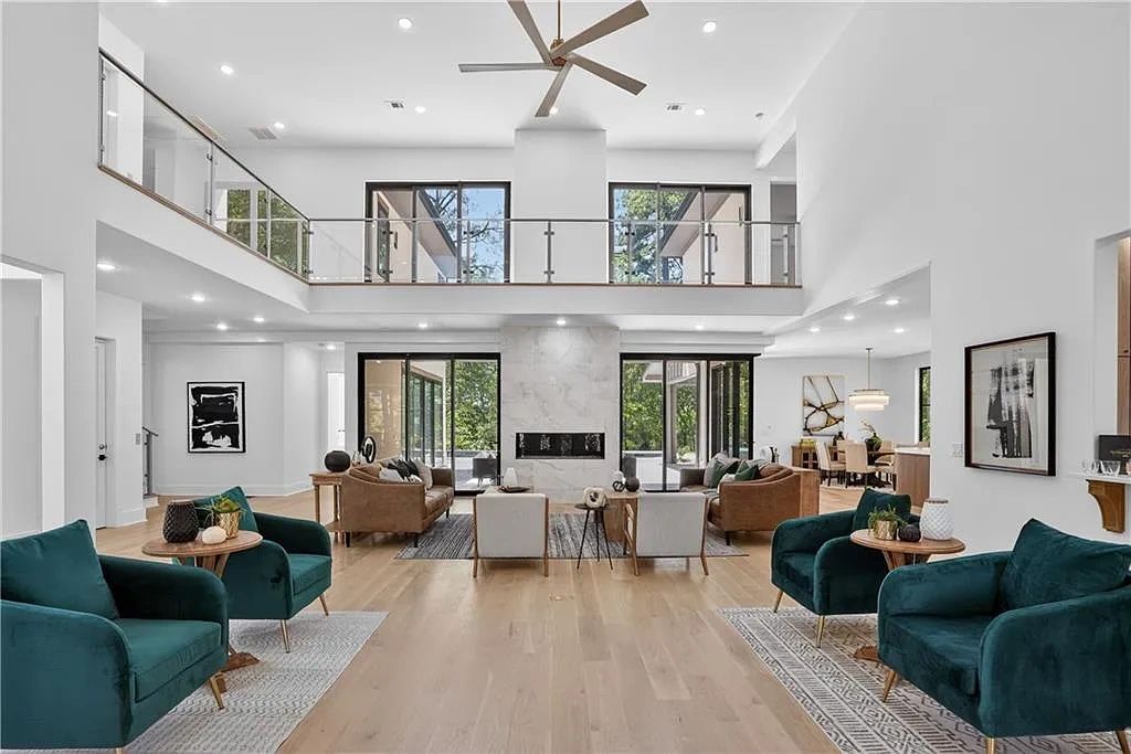 Spacious modern living room with glass balcony and large windows.