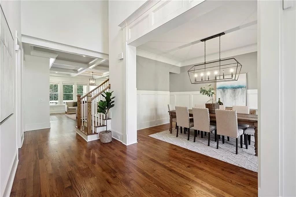 Bright modern dining room with wooden floors and beige chairs.