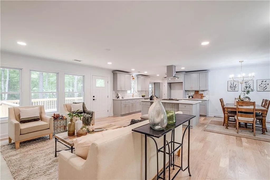 Bright open living area with beige furniture and modern kitchen.