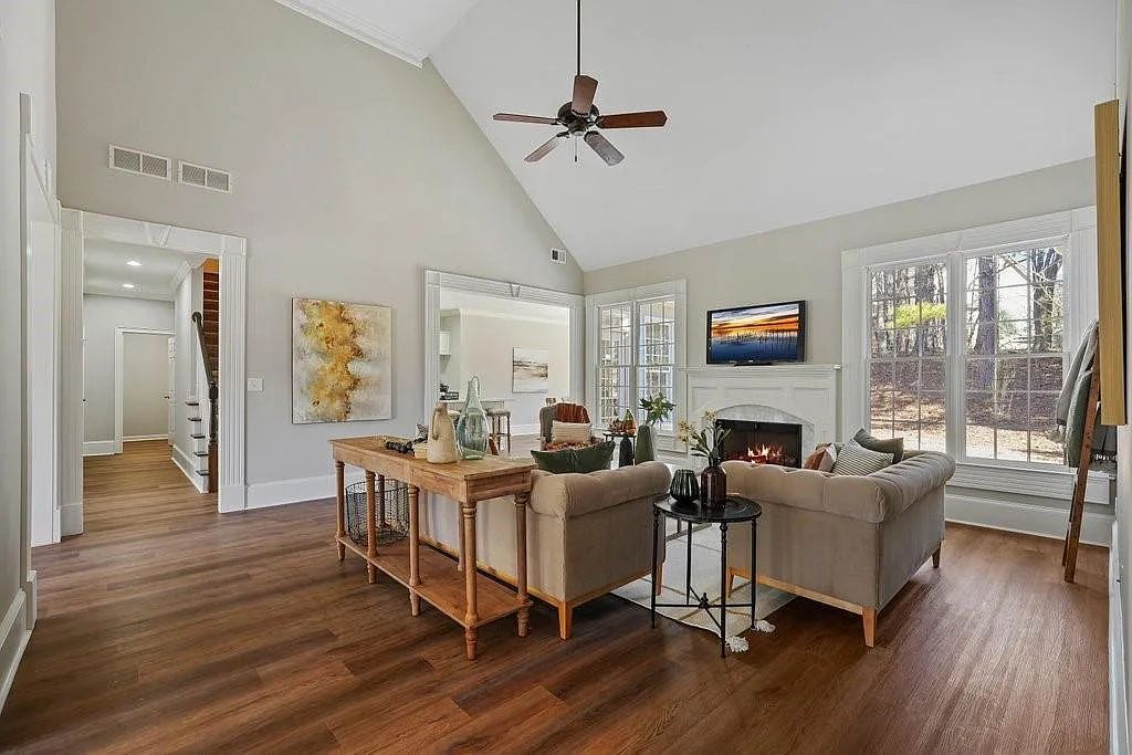 Spacious living room with high ceilings, cozy fireplace, and large windows.