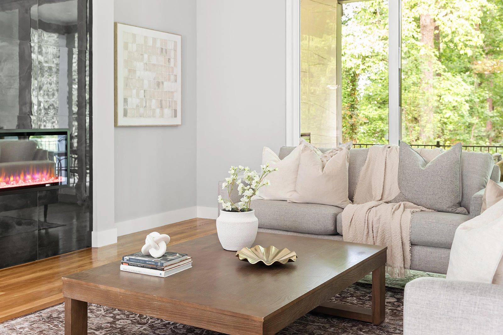 Bright, modern living room with a cozy gray sofa and fireplace.