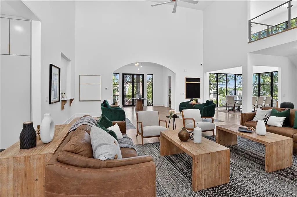 Spacious modern living room with leather sofas and wooden tables.