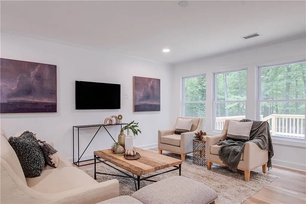 Bright modern living room with beige furniture and large windows.