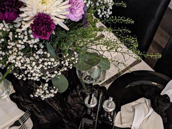 Elegant table setting with floral centerpiece and black accents.