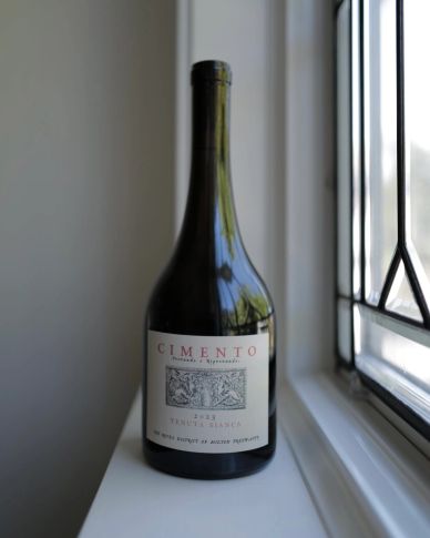 A bottle of Cimento wine on a windowsill.