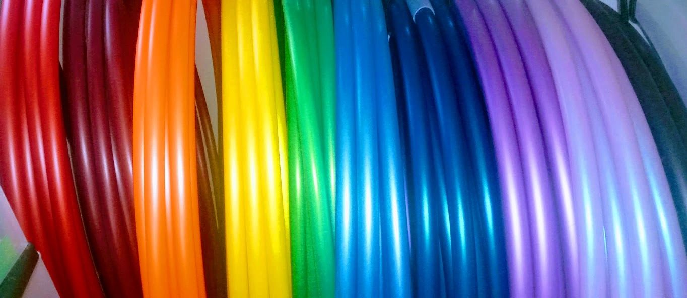 Colorful hula hoops arranged in a gradient from red to black.