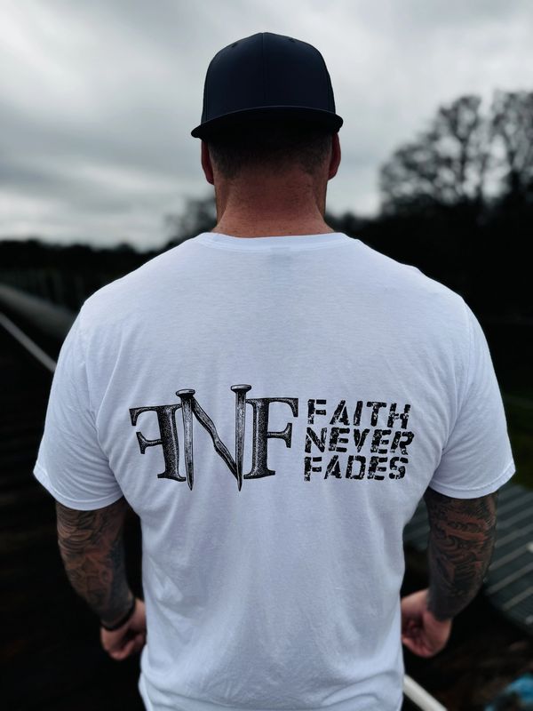 Man wearing a white t-shirt with the text 'Faith Never Fades'.