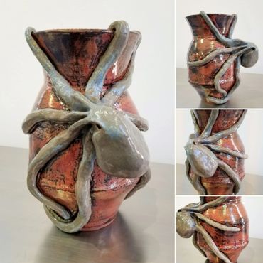 Ceramic vase with a detailed spider sculpture wrapped around it.