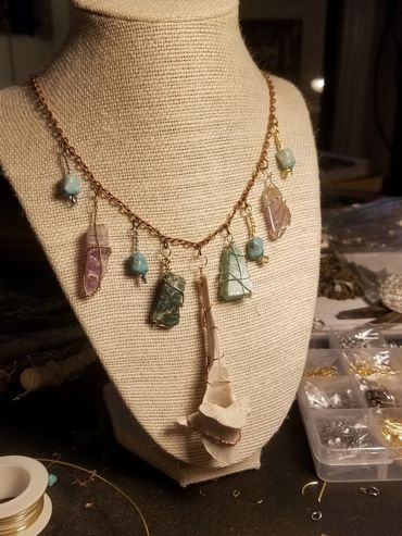 Handcrafted necklace with various polished stones on display.