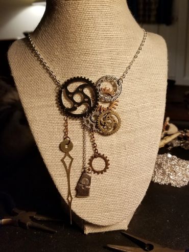 Steampunk-inspired necklace with gears and mechanical elements on display.