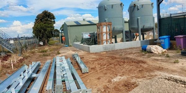 Construction site with metal beams and tanks.