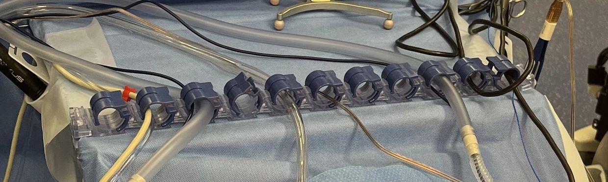 Medical tubes and cables arranged on blue surgical drape.