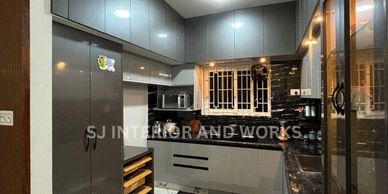 Modern kitchen with grey cabinets, black countertops, and marble flooring.