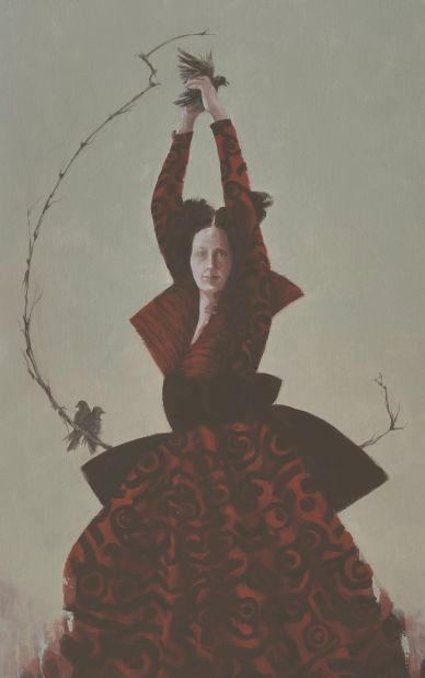 Woman in a dramatic red and black dress holding a bird with branches forming a circle around her.