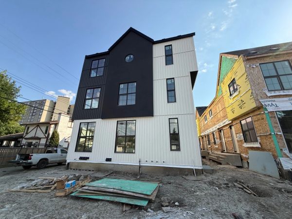 Modern house with black and white exterior under construction.