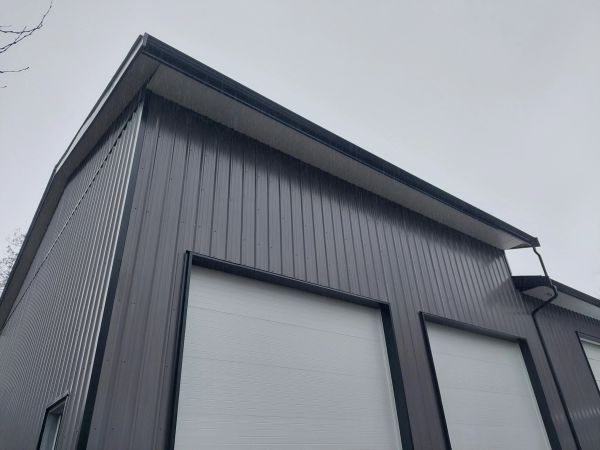 Gray metal warehouse exterior with garage doors.