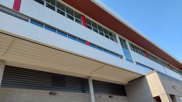 Modern industrial building facade with a clear blue sky.
