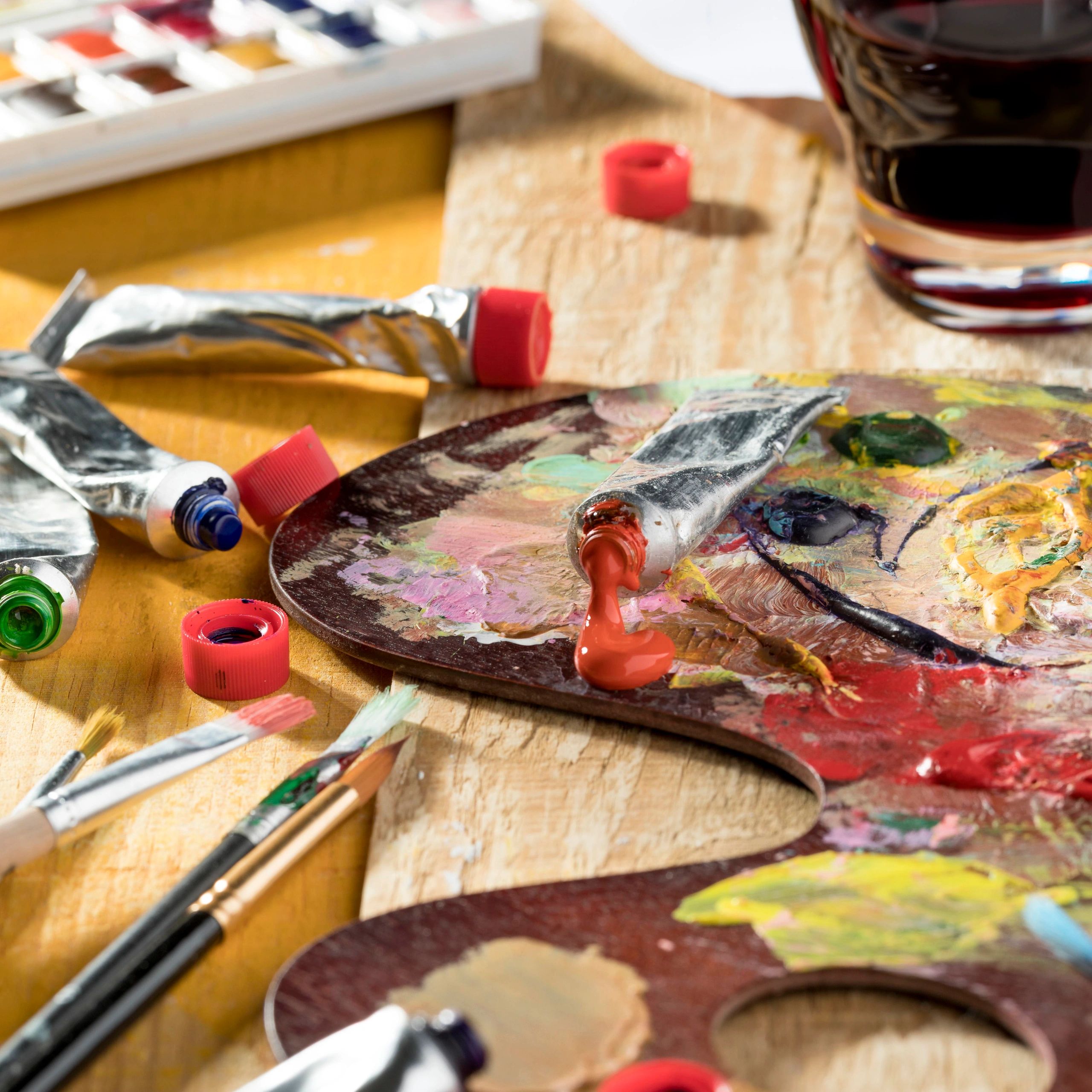 Paint palette with glass of red wine