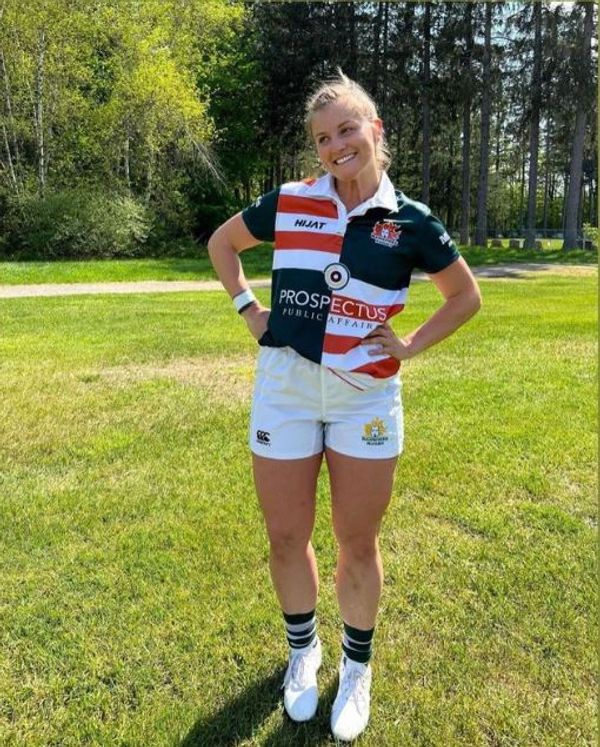 Woman in rugby uniform smiling outdoors. Ottawa beaver Rugby Club collaboration with Hijat Sports.