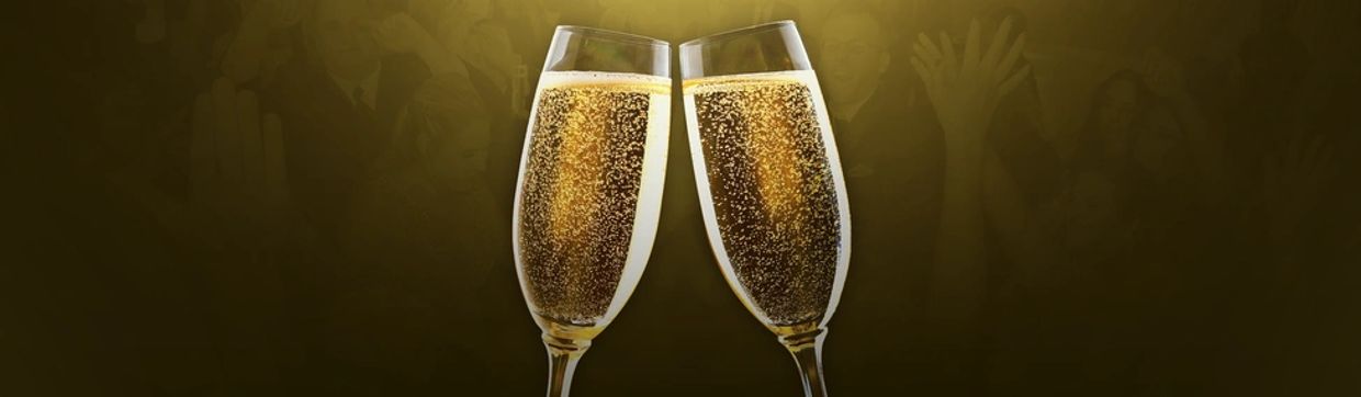 Two champagne flutes clinking in a toast, with blurry figures in the background.