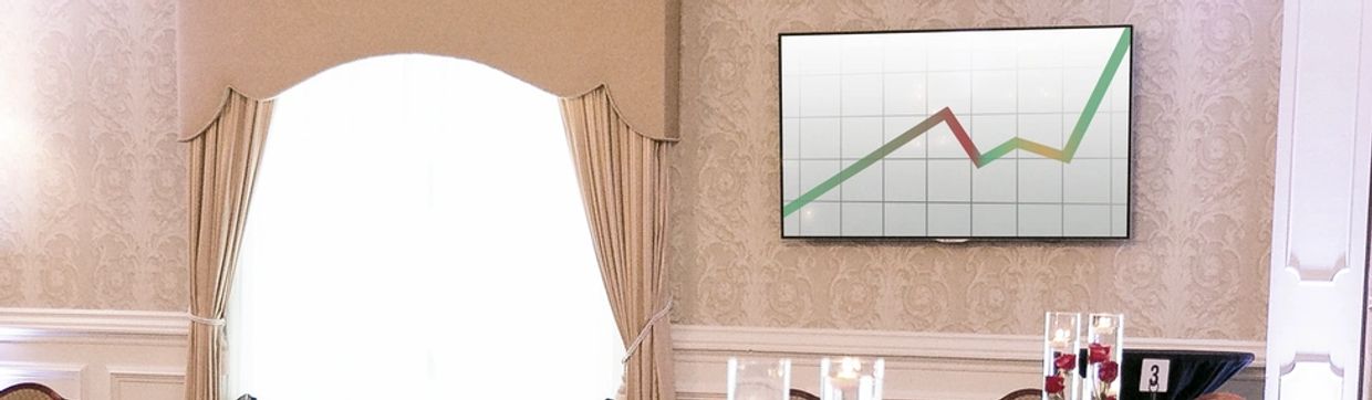A meeting room with elegant decor, a large window, and a screen displaying a line graph.