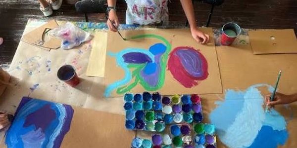 Children painting colorful abstract shapes on paper.
