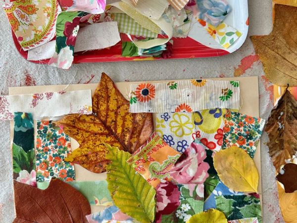 Craft project with fall leaves and fabric pieces.