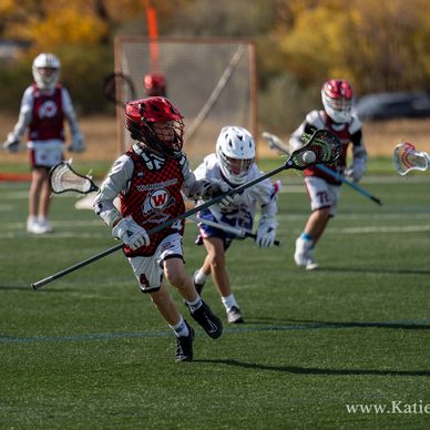 lacrosse player running with the ball in his stick